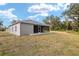 House back view showcasing screened lanai and landscaping at 39926 Parkinsonia St, Lady Lake, FL 32159