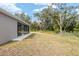 House backyard view with screened lanai and natural surroundings at 39926 Parkinsonia St, Lady Lake, FL 32159