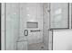 Walk-in shower with marble tile and built-in seat at 39926 Parkinsonia St, Lady Lake, FL 32159