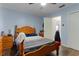 Bedroom with light blue walls, wooden bed frame, and tile floors at 4138 Cr 316, Bushnell, FL 33513