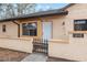 Front door and small gate of tan stucco house with a brown roof at 56 Pine Trak # 101E, Ocala, FL 34472