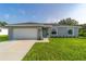 Charming single-story home with a welcoming teal front door and landscaped yard at 7077 Sw 134Th St, Ocala, FL 34473