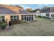Elevated view of a backyard with a screened lanai, grill, and well-maintained lawn at 7102 Sw 91St Ct, Ocala, FL 34481