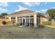 Back view of the home featuring a screened-in patio and grassy yard at 7102 Sw 91St Ct, Ocala, FL 34481