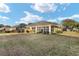 Backyard view of the house with a screened porch and green lawn at 7102 Sw 91St Ct, Ocala, FL 34481