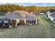 Florida home with a screened-in lanai, lush lawn, and mature trees at 7102 Sw 91St Ct, Ocala, FL 34481