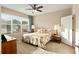 Well-lit bedroom with ceiling fan, large window, and carpeted floor at 7102 Sw 91St Ct, Ocala, FL 34481
