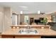Kitchen features double stainless steel sink, breakfast bar, and view of the living room at 7102 Sw 91St Ct, Ocala, FL 34481
