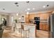 Well-equipped kitchen featuring modern appliances, wood cabinets, and a breakfast bar at 7102 Sw 91St Ct, Ocala, FL 34481