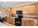 Bright kitchen boasts wood cabinets, black appliances, and ample counter space at 7102 Sw 91St Ct, Ocala, FL 34481