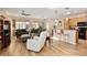 Open-concept living room and kitchen area with wood floors, ceiling fan, and access to a patio at 7102 Sw 91St Ct, Ocala, FL 34481