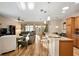 Open living room and kitchen area with breakfast bar, wood floors, and neutral decor at 7102 Sw 91St Ct, Ocala, FL 34481