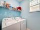 Bright laundry room with washer, dryer, and shelving at 7883 Sw 89Th Cir, Ocala, FL 34481