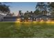 House exterior at dusk; features three-car garage and landscaped yard at 10120 Sw 49Th Ave, Ocala, FL 34476