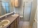Bathroom with double sinks, shower, and wood cabinets at 10913 Sw 69Th Cir, Ocala, FL 34476