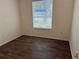 Bright bedroom with wood-look floors and window with blinds at 10913 Sw 69Th Cir, Ocala, FL 34476