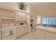 Bright kitchen with white cabinets, an island, and access to laundry at 8225 Sw 108Th Loop, Ocala, FL 34481