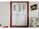 White front door with sidelights and storm door at 9646 Sw 92 Place Rd, Ocala, FL 34481