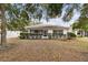 Back exterior view showing a house with a screened porch and landscaping at 9646 Sw 92 Place Rd, Ocala, FL 34481