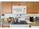 Kitchen features a white stove top, microwave, and ample wood cabinets at 9646 Sw 92 Place Rd, Ocala, FL 34481