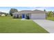 Newly built home with a gray exterior, blue door, and attached garage at 115 Guava Place Dr, Ocklawaha, FL 32179
