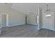 Open living room with vaulted ceiling and neutral decor at 115 Guava Place Dr, Ocklawaha, FL 32179