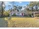 Gray house with red door, green lawn, and mature trees at 14880 Se 36Th Ave, Summerfield, FL 34491