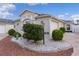 Tan house with white accents, manicured landscaping, and a curved driveway at 1673 Belle Grove Dr, The Villages, FL 32162