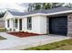 New home with white exterior, black garage door, and stone accents at 16919 Sw 27Th Ave, Ocala, FL 34473