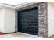 Black garage door with stone accent wall at 16919 Sw 27Th Ave, Ocala, FL 34473