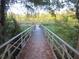 Wooden boardwalk path leads to a tranquil waterfront with lush foliage at 17935 Se 10Th Pl, Silver Springs, FL 34488
