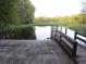 Concrete boat ramp with wooden dock and tranquil waterfront views at 17935 Se 10Th Pl, Silver Springs, FL 34488