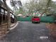 Gravel driveway with a red truck parked and green privacy fence at 17935 Se 10Th Pl, Silver Springs, FL 34488