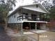 Side view of an elevated home with a large screened porch and parking at 17935 Se 10Th Pl, Silver Springs, FL 34488