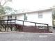 Elevated home with a ramp, deck, and spacious parking area at 17935 Se 10Th Pl, Silver Springs, FL 34488