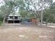 Elevated home with a deck, surrounded by lush greenery at 17935 Se 10Th Pl, Silver Springs, FL 34488