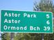 Green road sign indicating directions to Astor Park, Astor, and Ormond Beach at 17935 Se 10Th Pl, Silver Springs, FL 34488