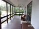 Relaxing screened porch with wooden bench and ceiling fan at 17935 Se 10Th Pl, Silver Springs, FL 34488