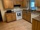Kitchen with wood cabinets, laminate flooring, and white appliances at 1855 Ne 23Rd St, Ocala, FL 34470