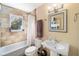 Clean bathroom with tub shower, pedestal sink, and tiled walls at 21959 Nw 6Th St, Dunnellon, FL 34431