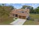 Two-story home with brown roof, two-car garage, and landscaping at 21959 Nw 6Th St, Dunnellon, FL 34431
