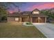 Two-story house with brown exterior, two-car garage, and a well-manicured lawn at 21959 Nw 6Th St, Dunnellon, FL 34431
