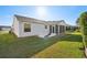 Rear view of house showing a screened porch and yard at 2427 Due West Dr, The Villages, FL 32162