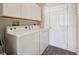 Laundry room with washer, dryer, and overhead cabinets at 2427 Due West Dr, The Villages, FL 32162