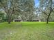 Two barns on a large green lot with mature trees at 10502 Se 29Th Ave, Ocala, FL 34480