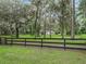 House exterior view with a black fence and lush green landscape at 10502 Se 29Th Ave, Ocala, FL 34480