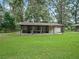 Horse stables with covered walkway and large grassy area at 10502 Se 29Th Ave, Ocala, FL 34480