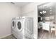 Bright laundry room with washer, dryer, and view to kitchen at 3321 Sw 153Rd Place Rd, Ocala, FL 34473