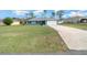 Single-Gathering home with blue exterior, a white garage door, and a well-manicured lawn at 3386 Sw 126Th Lane Rd, Ocala, FL 34473