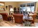 Living room with leather furniture, hardwood floors, and view of screened porch at 4707 River Ridge Dr, Leesburg, FL 34748